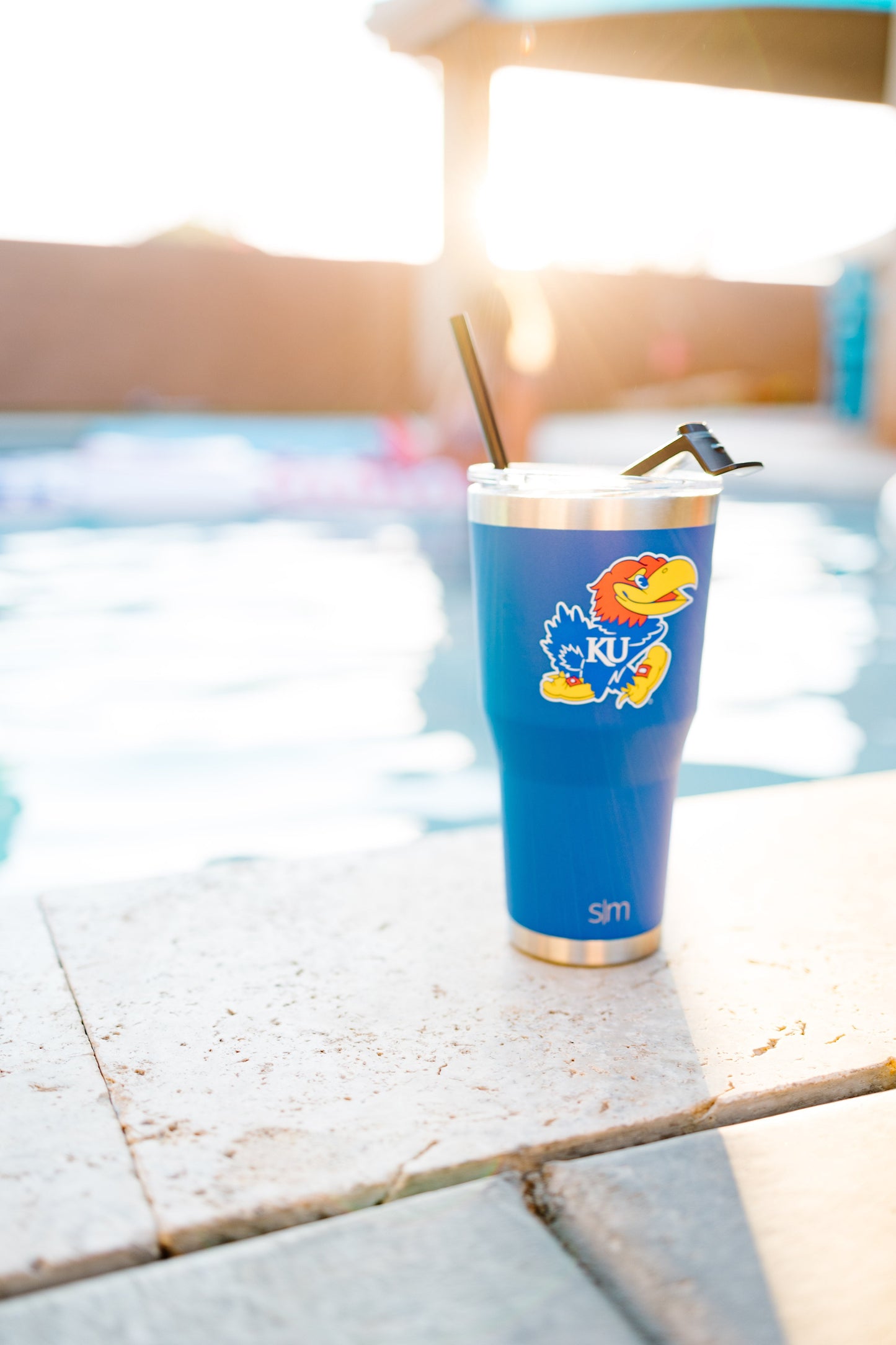 Royal blue tumbler in sunlight with white, cream, and golden tones against a soft tan and beige background.