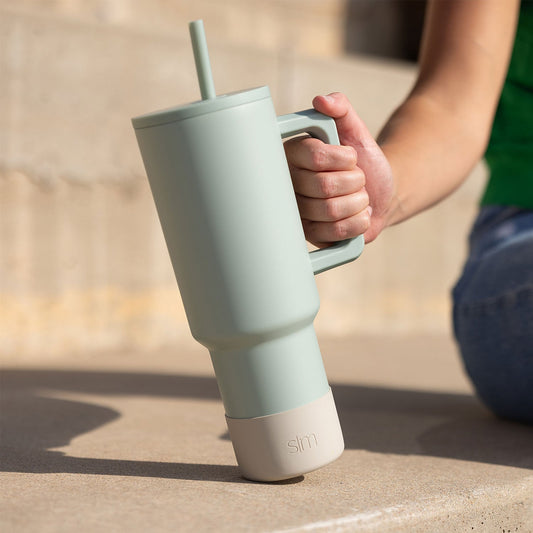 Light sage green tumbler with cream-colored base, shown against white background.