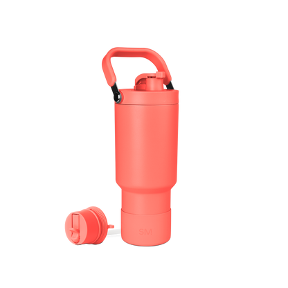 Coral-red water bottle with accessories on white background